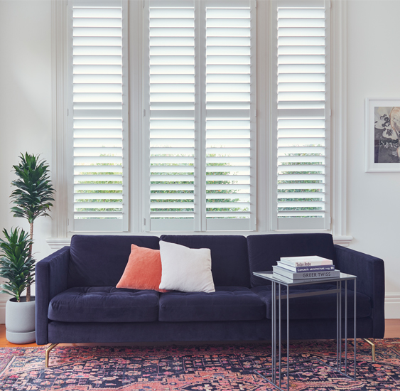 White shutters in front of blue couch