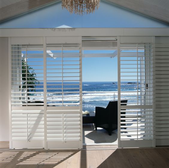 White Sliding shutters overlooking beach and ocean